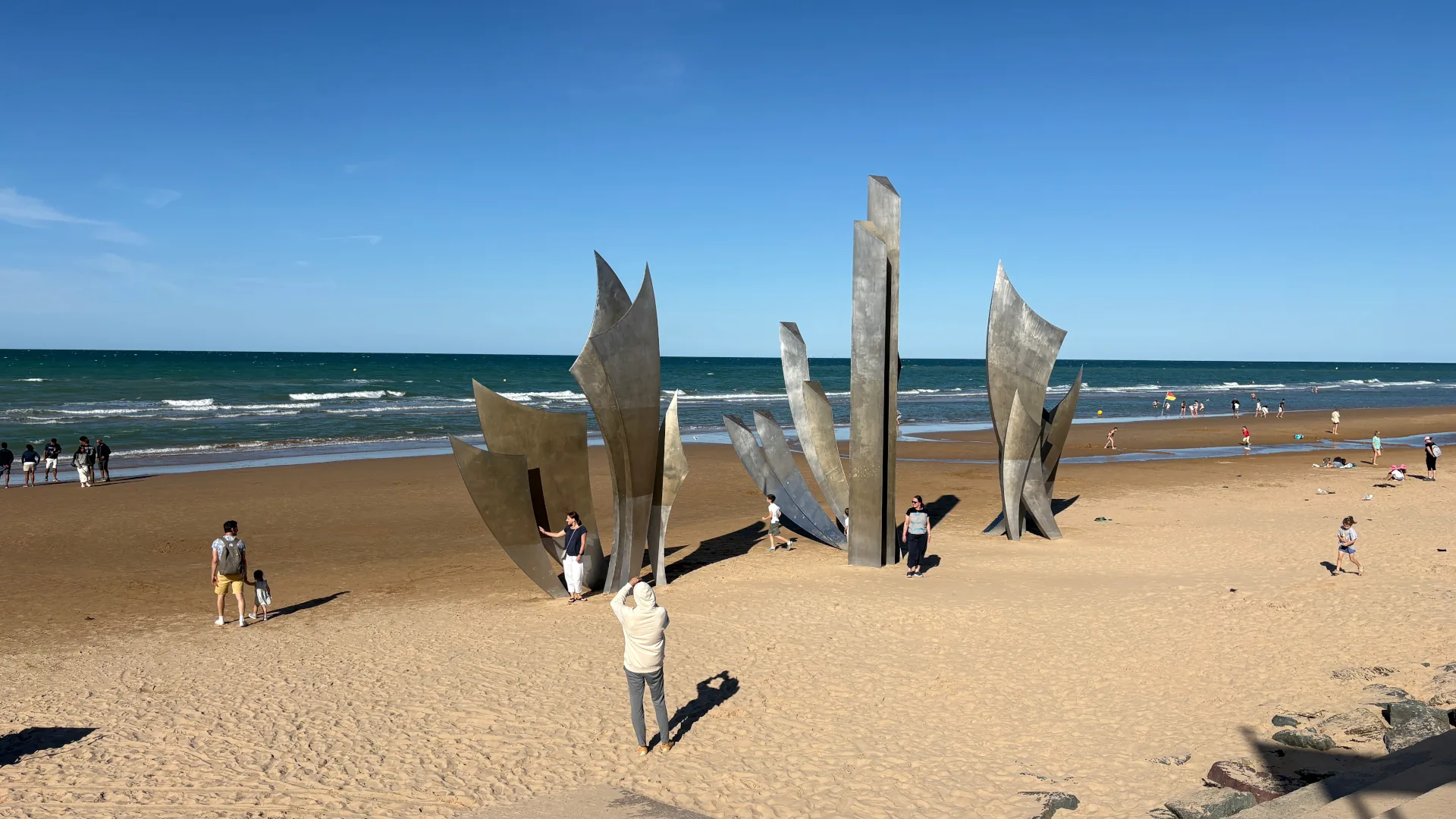 Omaha Beach im Sommer 2026: Das Monument „Les Braves“ erinnert an die alliierte Landung vom 6. Juni 1944. Heute begegnen sich an diesem Strand Erinnerung, Geschichte und friedlicher Alltag. Foto: André Eymann, 2026.