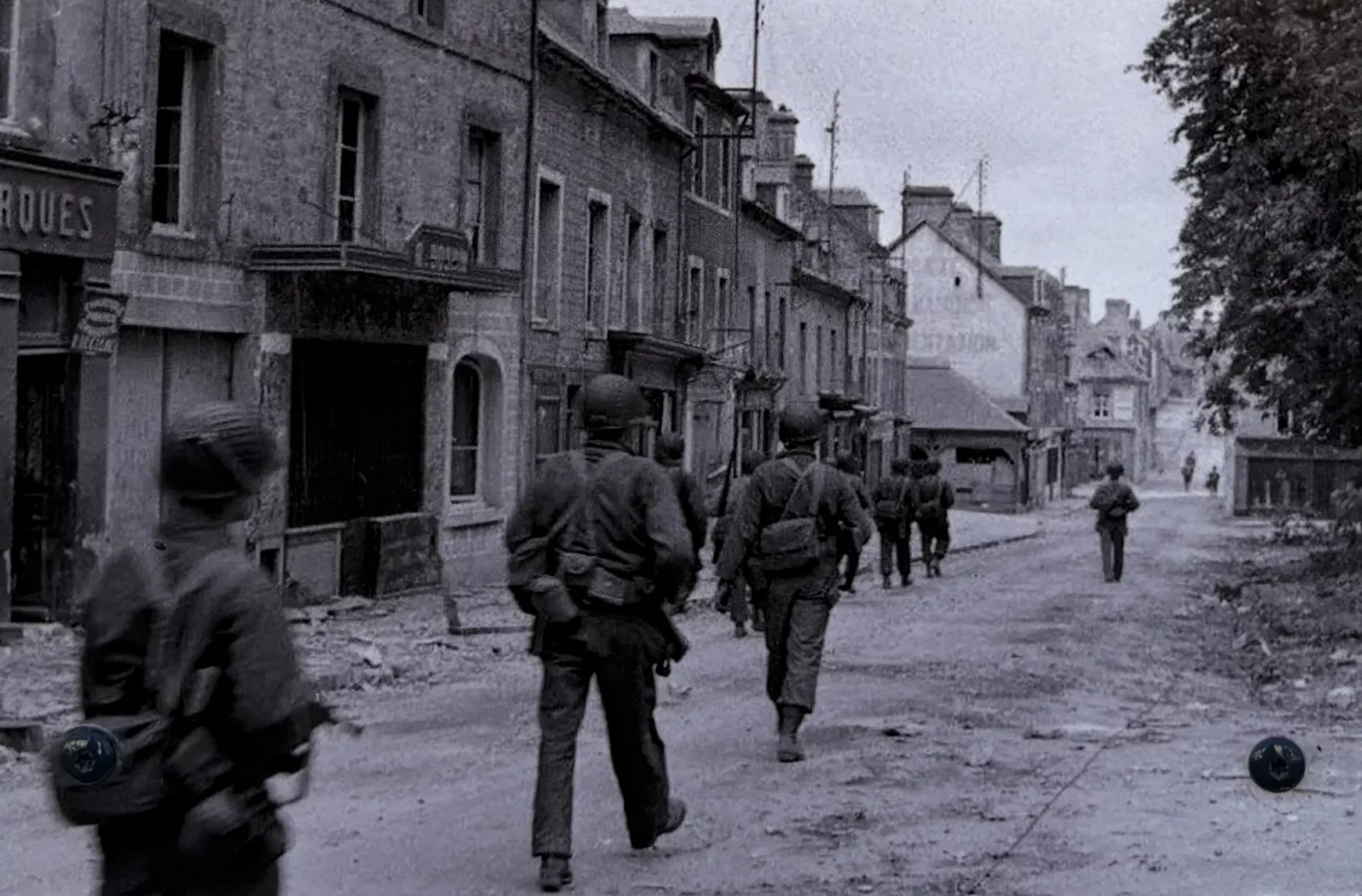 Amerikanische Soldaten in Sainte-Mère-Église während der Befreiung der Normandie. Historische Aufnahmen wie diese zeigen die reale Welt hinter den Schauplätzen, die Call of Duty Jahrzehnte später digital nachbildete.